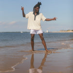 Man wearing polo while playing in the shallow water at the beach
