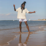 Man wearing polo while playing in the shallow water at the beach