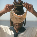 Male model holding visor in hands over eyes