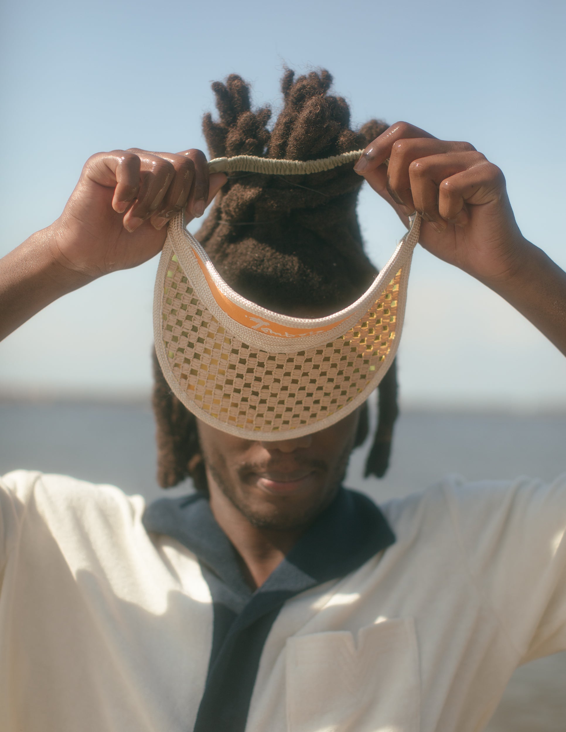 Male model holding visor in hands over eyes