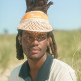 Man wearing Tombolo visor in close up shot displays the navy collar of the polo
