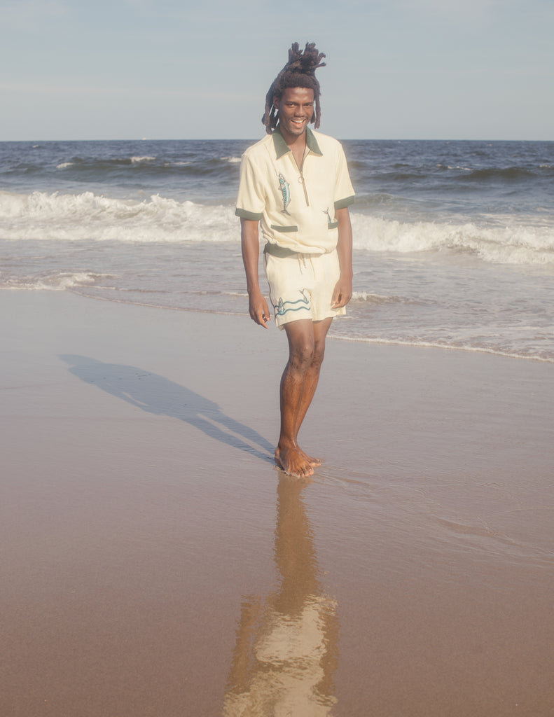 Male model in full set smiling at beach