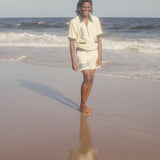 Male model wearing The Angler shirt on the beach with matching shorts