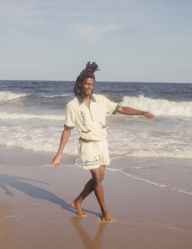 Male model wearing The Angler shirt on the beach with matching shorts