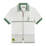 Flat lay product photo of shirt showing light green contrast collar and sleeve borders along with embroidered tennis player and ball and mesh net pockets