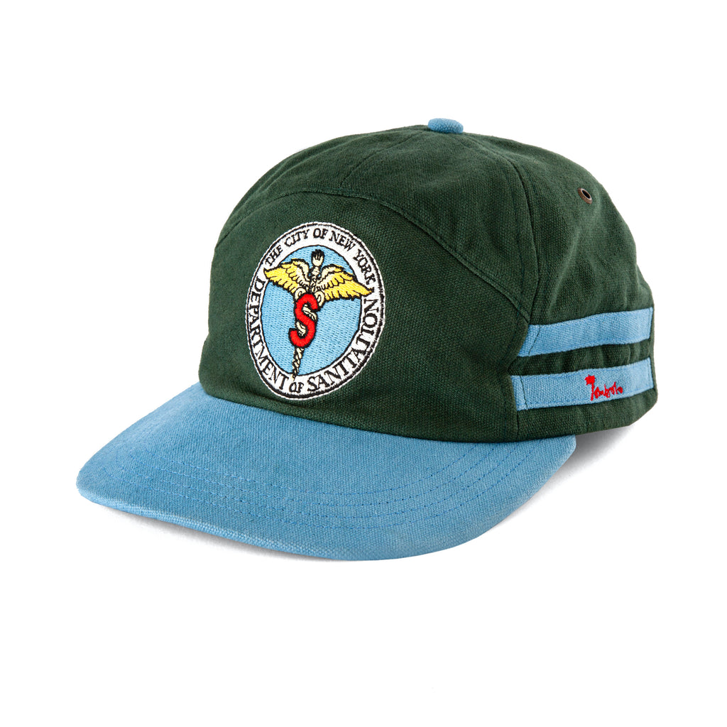 Right front side view of cap showing the blue stripes with the red Tombolo logo inside bottom stripe