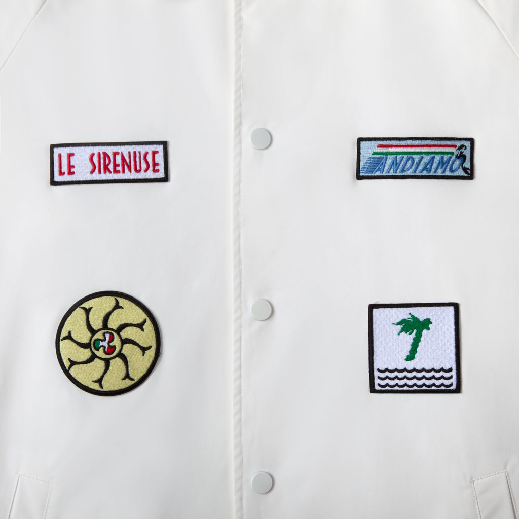 Close up of four patches, andiamo, le sirenuse, fan made of mermaid tails, and tombolo palm tree with three waves beneath