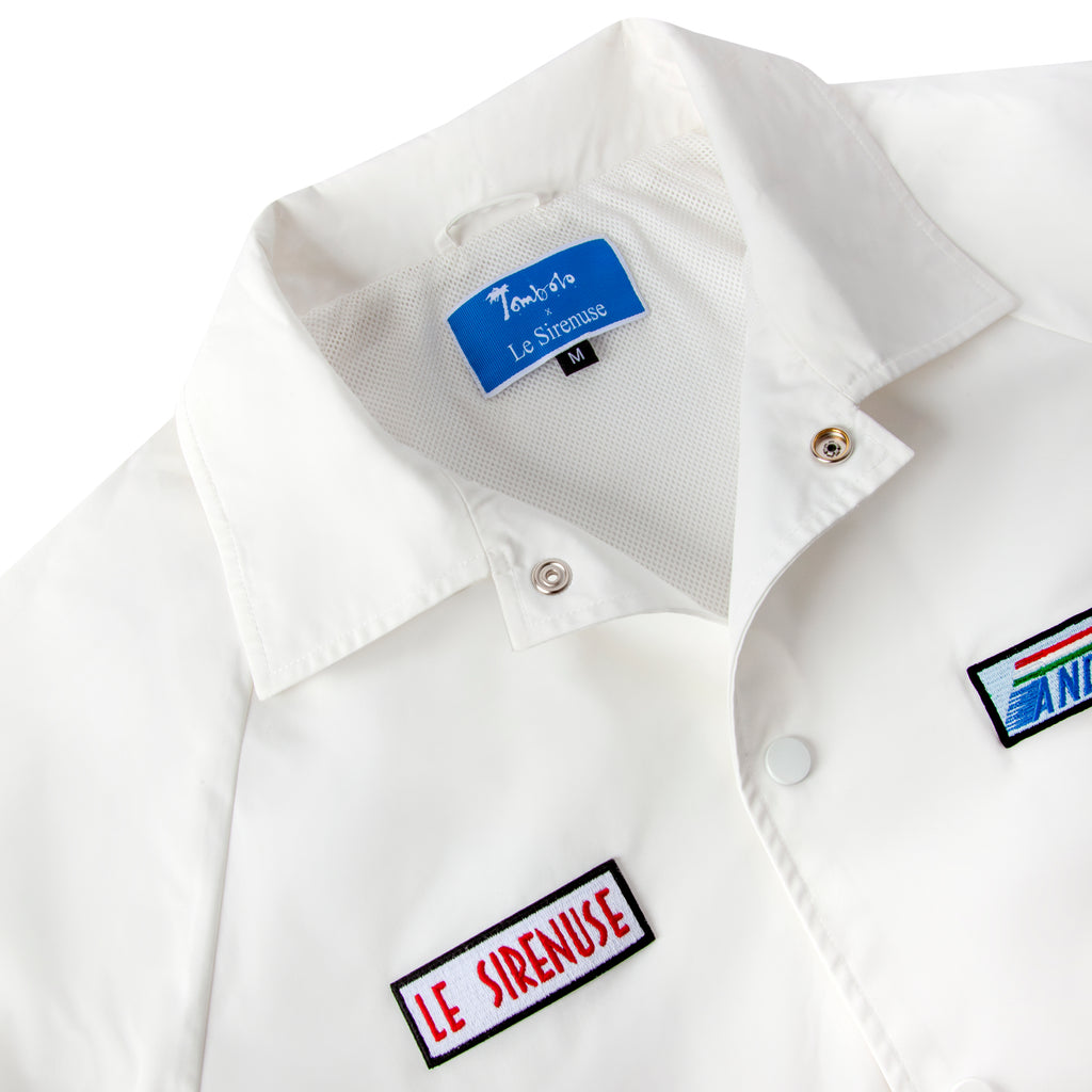 Close up of the jacket collar shwoing the tombolo x le sirenuse tag and snap closure