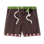 Cabana shorts in brown linen with embroidered red chili peppers and white chili flowers forming a border along both leg openings. Green waistband.  Drawstring untied and zipper undone to show that there is a functional fly.