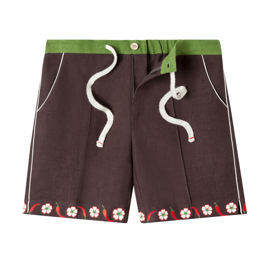 Cabana shorts in brown linen with embroidered red chili peppers and white chili flowers forming a border along both leg openings. Green waistband.  Drawstring untied and zipper undone to show that there is a functional fly.