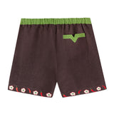 Back view of cabana shorts in brown linen with embroidered red chili peppers and white chili flowers forming a border along both leg openings. Green waistband and one back pocket with v-slit detail.
