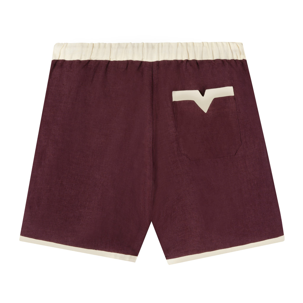 Back view of eggplant-colored linen cabana shirts with appliquéd and edge-embroidered grape vine.