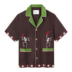 Casual, cabana style in brown linen with embroidered skeletons holding chili peppers on each front panel. Green combo color on collar and pocket strips.