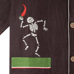 Close up view of embroidered skeleton holding a chili pepper. 