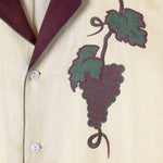 Close up view of appliqué and edge embroidered grape vine on shirt