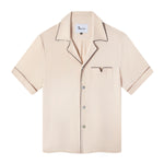 Front view of the Parchment Cabrisa shirt featuring window pane embroidery on sleeves and navy piping along the pocket and collar with grey white buttons down the front