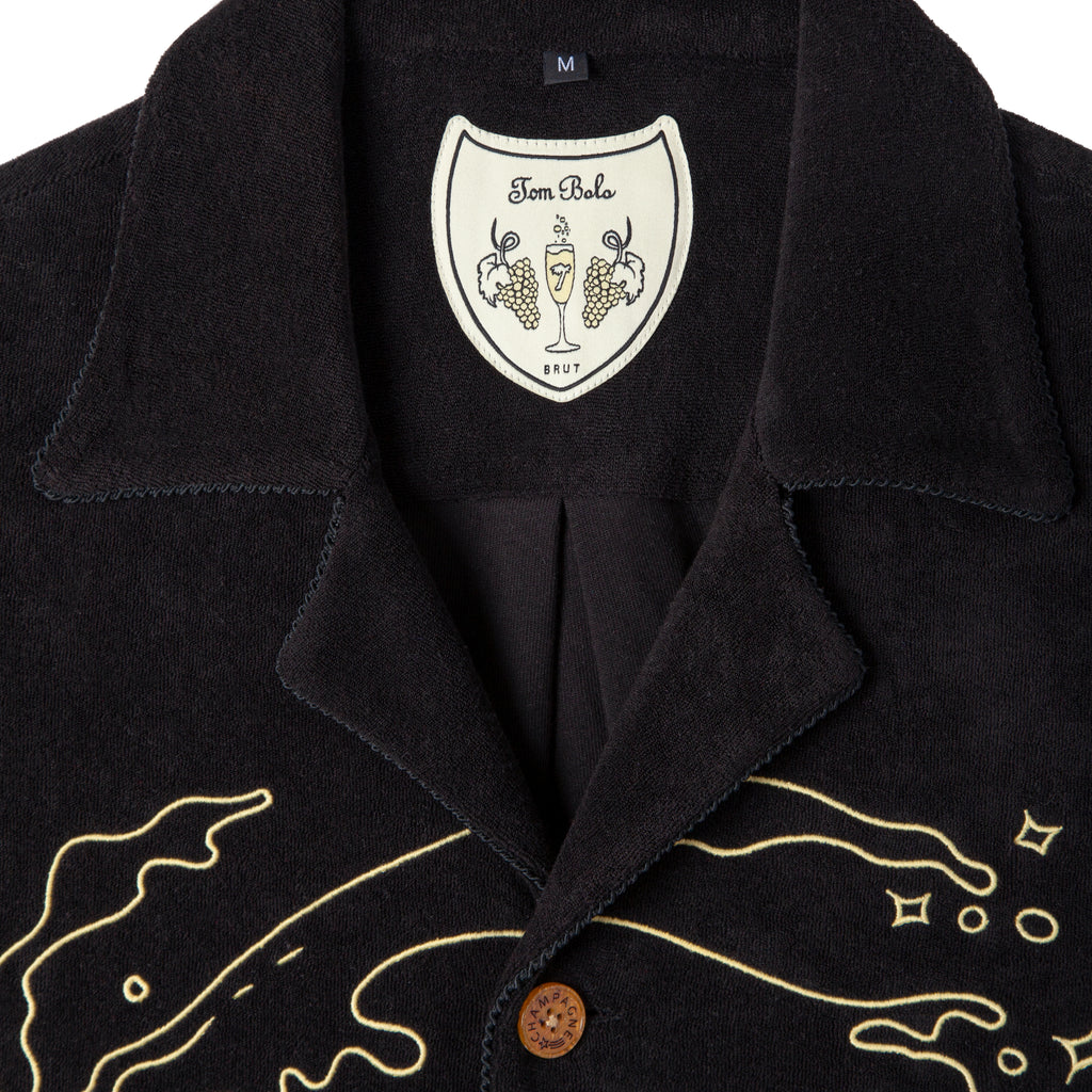 Close up of interior label showing Tom bolo Brut and a drawing of champagne flute with grapes