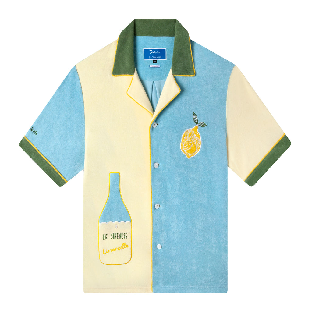  A color-blocked terrycloth rendition of the classic cabana shirt in cream, blue and green with yellow piping, the shirt highlights an embroidered Le Sirenuse limoncello bottle in lieu of a traditional pocket, and an embroidered mermaid lounges inside a lemon on the breast pocket