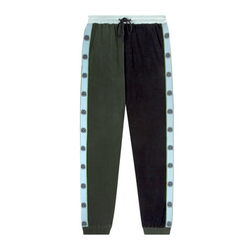 lay flat product photo of apres ski pants showing light blue, green, and black contrasts along with recurring sun motif down sides of legs 