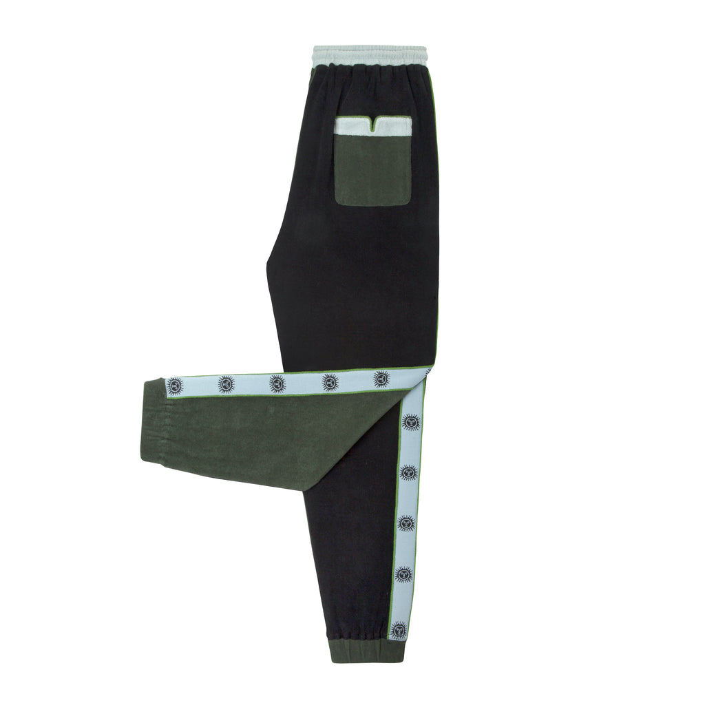 side view product photo of apres ski pants with one leg folded up. Also shows contrast light blue and green pocket