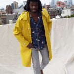 male model wearing shirt on rooftop under a yellow jacket
