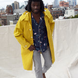 male model wearing shirt on rooftop under a yellow jacket