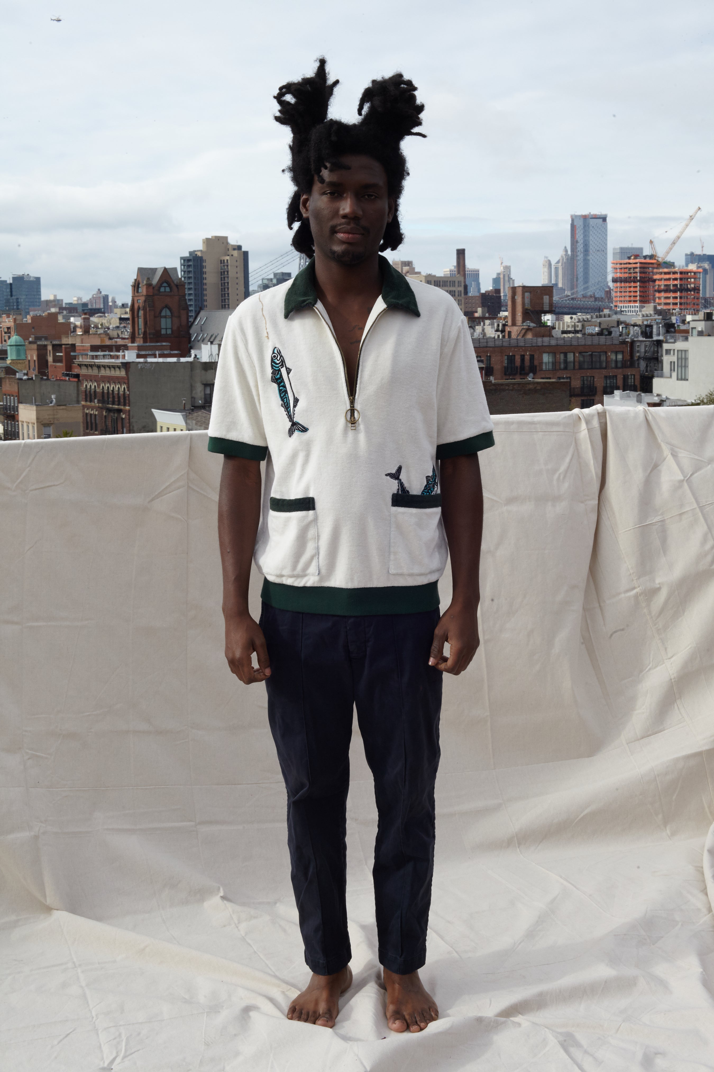Male model wearing the shirt on a rooftop in a city with black pants