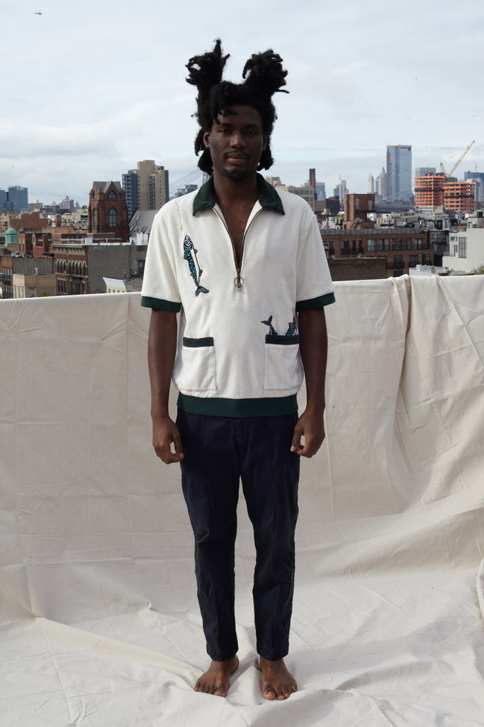 Male model wearing the shirt on a rooftop in a city with black pants