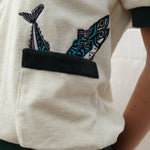 Close up of the right pocket lined with two embroidered fish