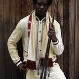 Male model holding skis in front of wooden wall