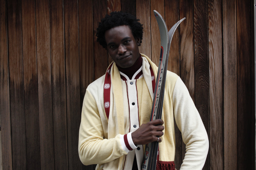 Male model close up holding skis and smiling at camera