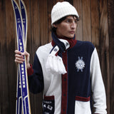 Male model in set with scarf holding a pair of skis