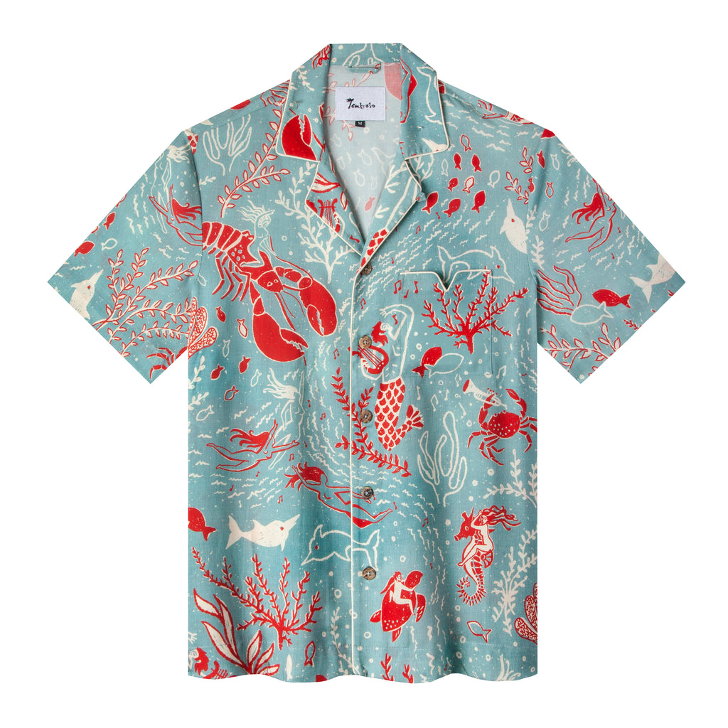 Front flat lay view of the shirt showing an array of semi-nude revelers making music among encouraging semi-tame sea creatures, with white piping, including V pocket, and the Print is matched on the pocket and across the front opening 