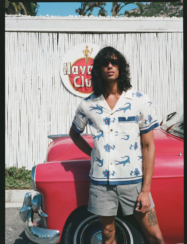 Male model wearing the shirt leaning on a red car