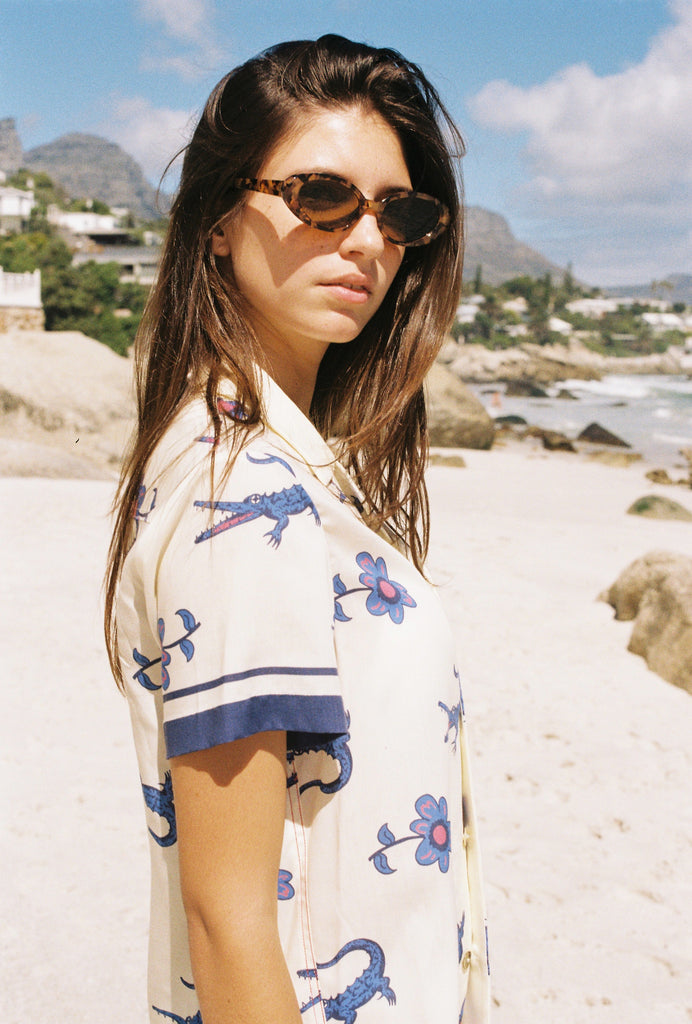 Female model on beach looking over left shoulder wearing the shirt