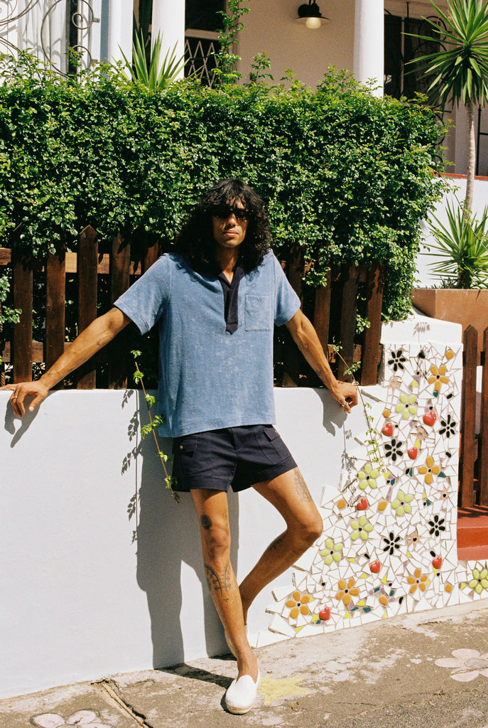 man leans against floral wall