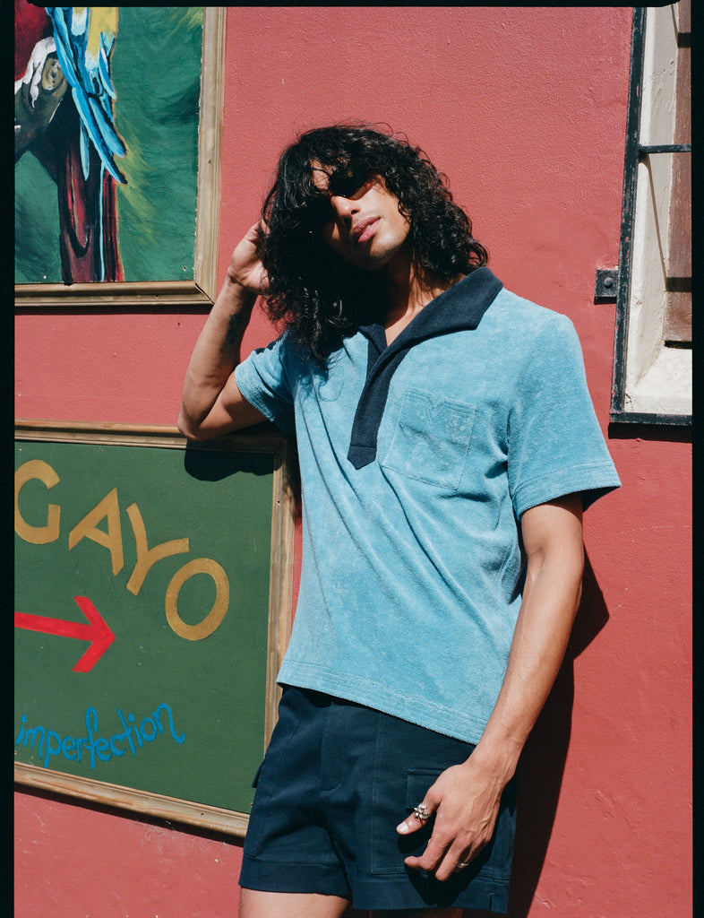 model leans against red wall