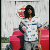 model leans against red car