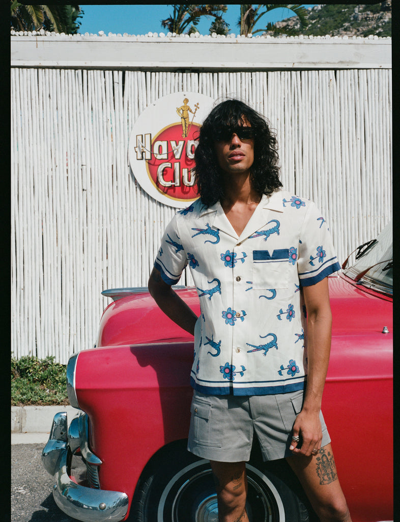 model leans against red car