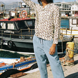 Male model wearing shirt with hands in his hair on a pier