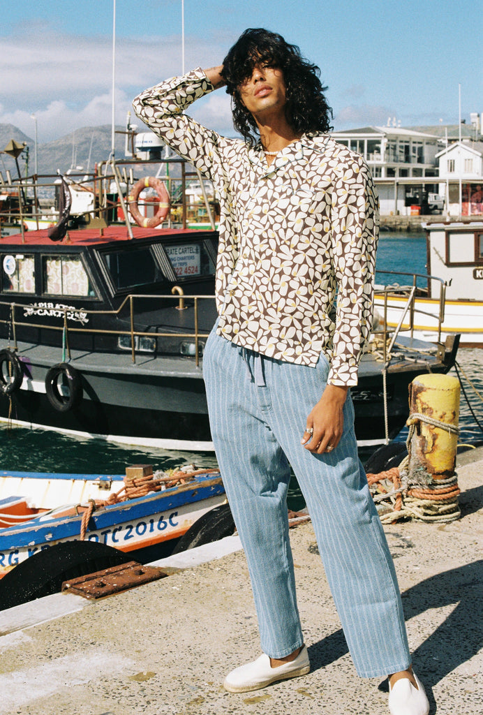 Male model wearing shirt with hands in his hair on a pier