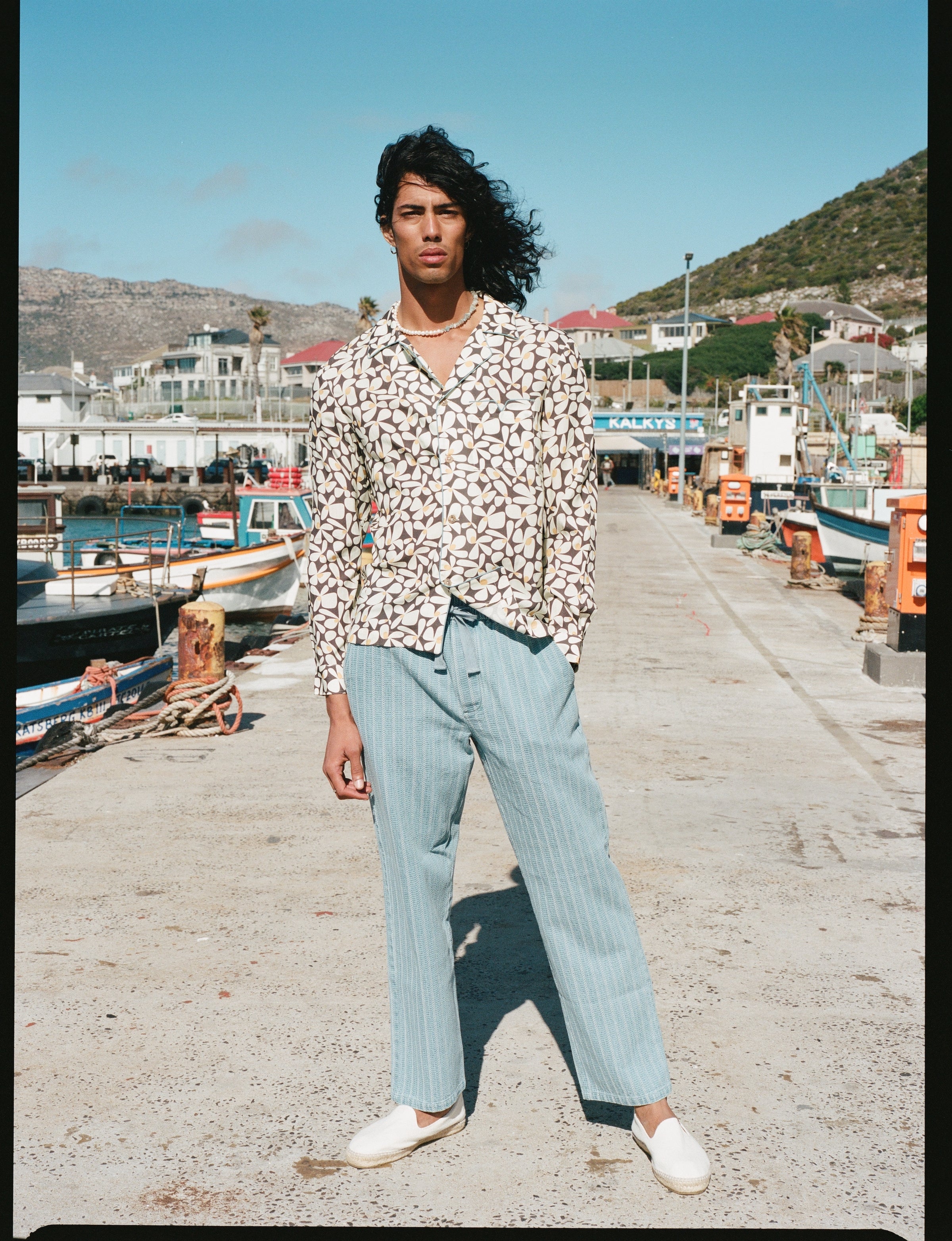 Male model posing in tee standing on pier