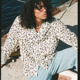 Male model gazing outwards in shirt and linen pants