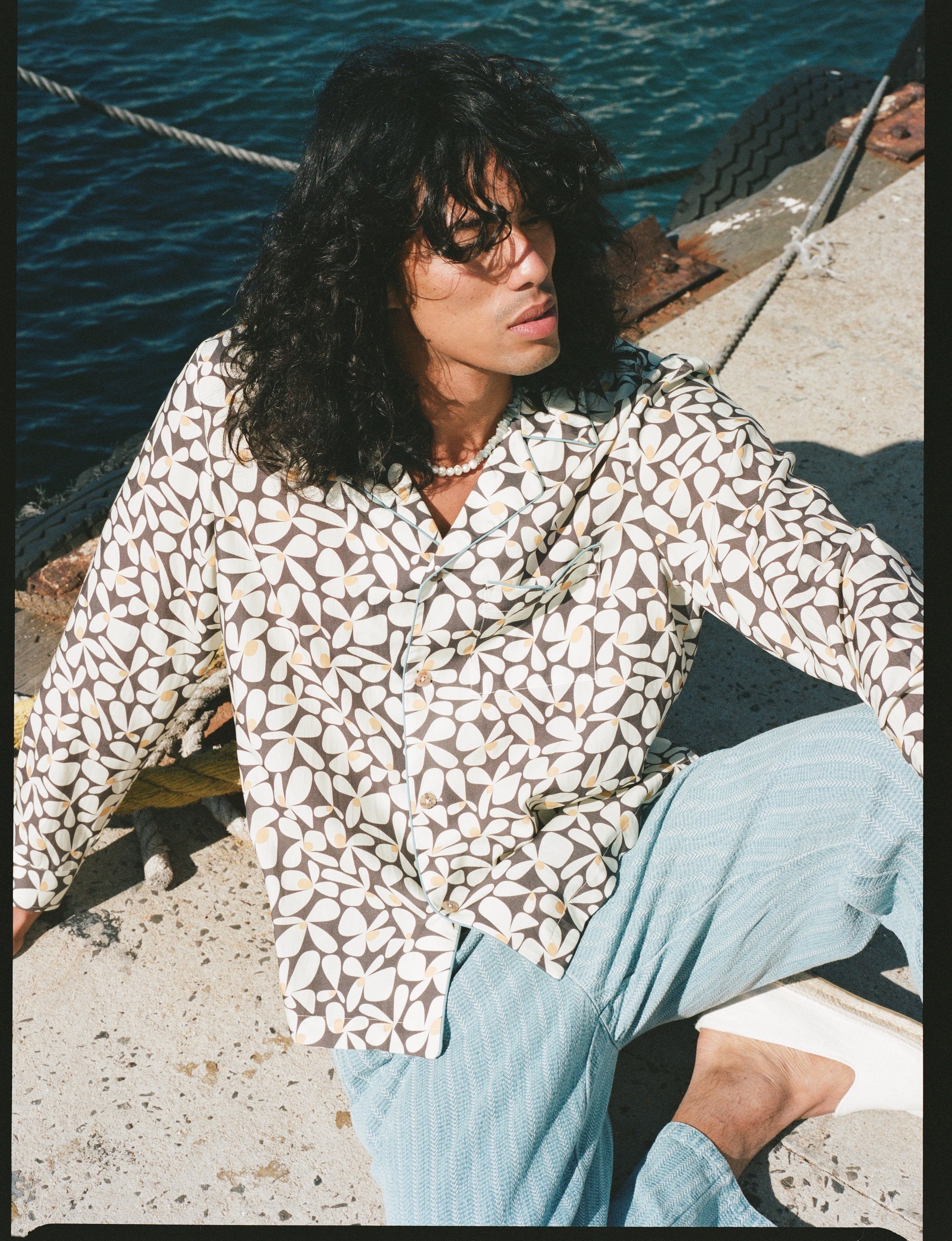 Male model gazing outwards in shirt and linen pants