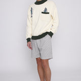 Male model wearing the angler sweater with shorts and a hat
