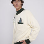 Male model looking at camera wearing sweater looking over his right shoulder