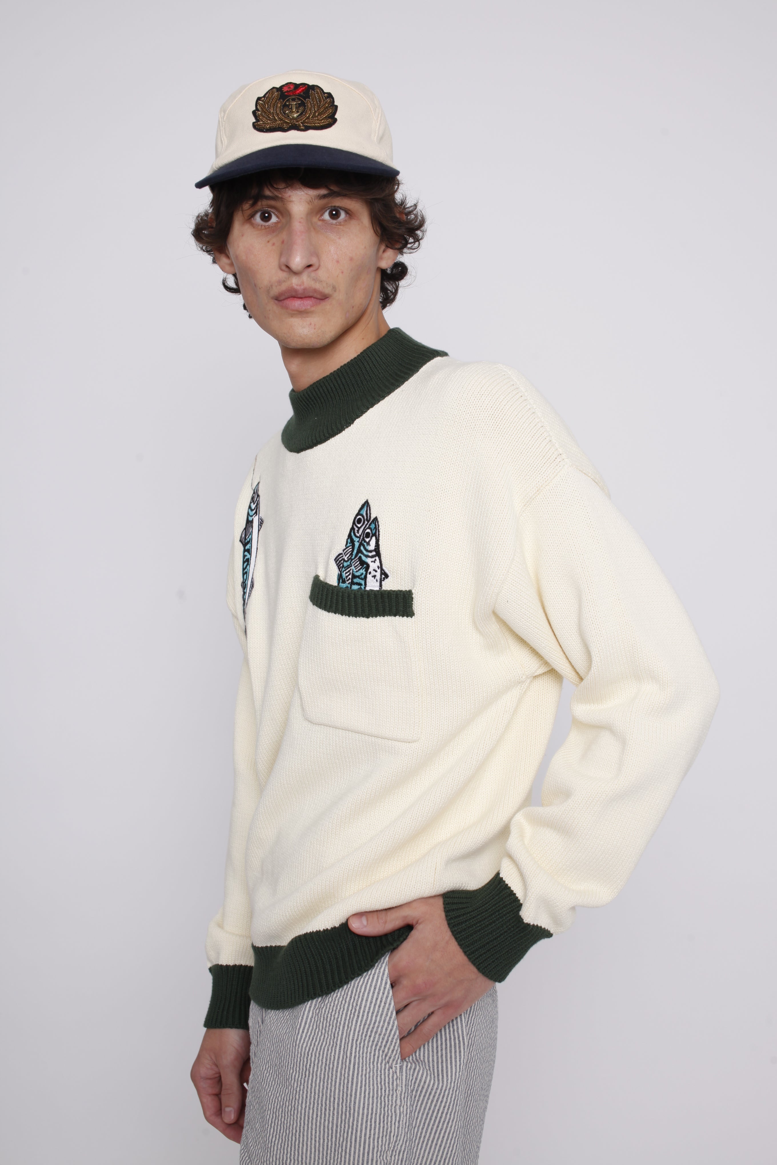 Male model looking at camera wearing sweater looking over his right shoulder