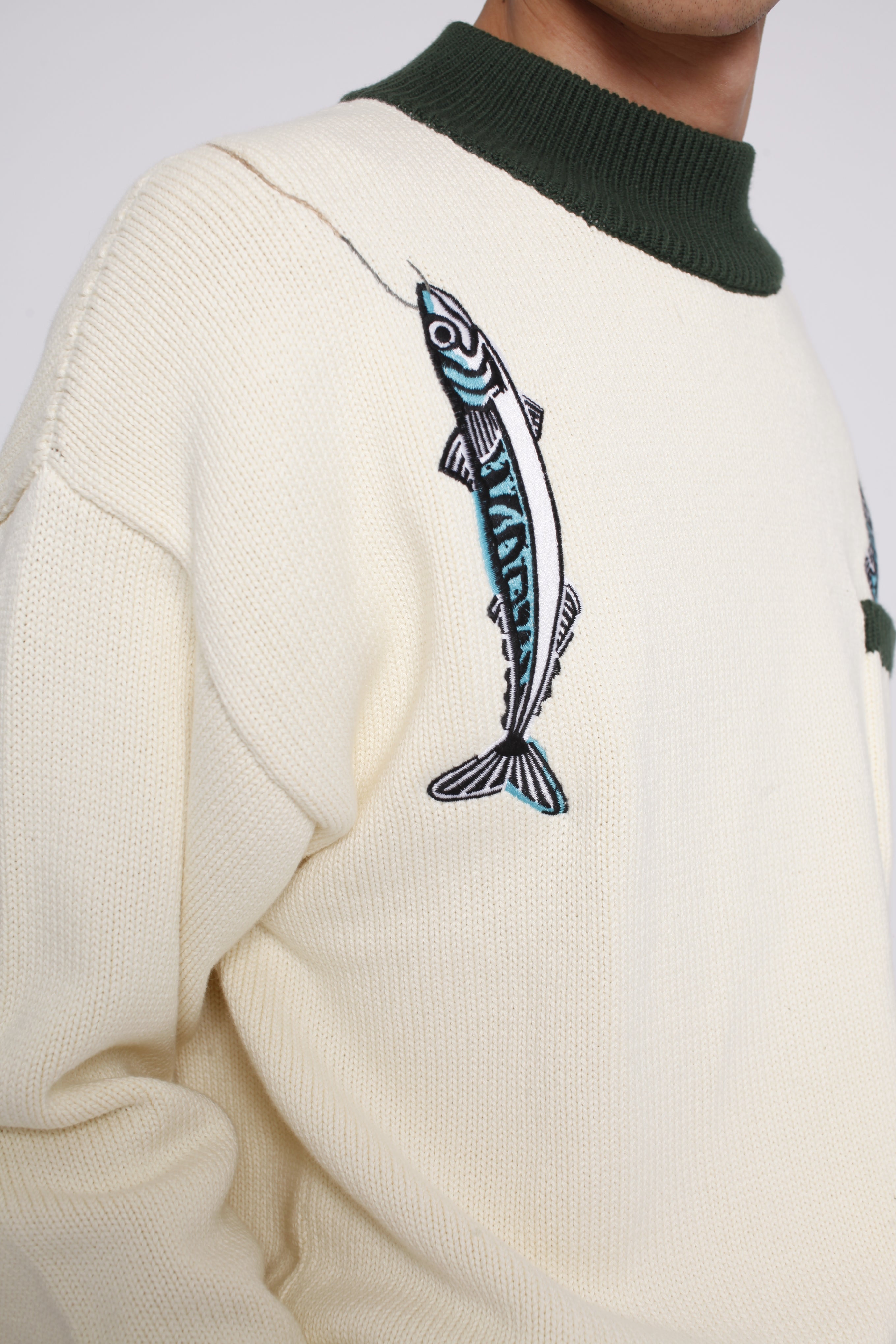 Close up of the embroidered over the shoulder fish and hook