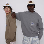 Male model wearing cap with arm on another male models back