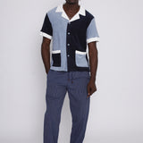 Full body view of male model wearing cap with blue two toned polo with pants